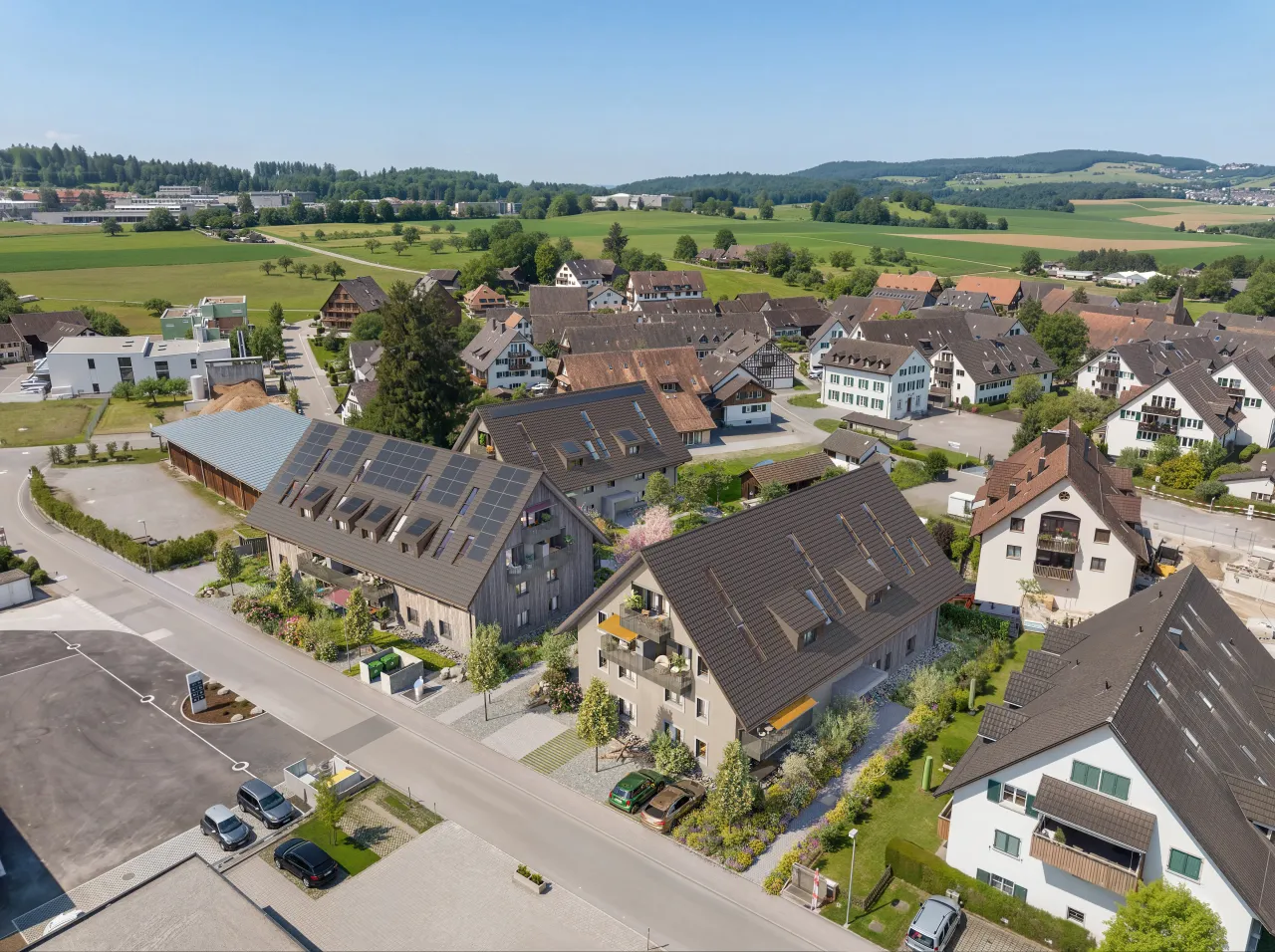 Bird's-eye rendering of a village centre with a new pitched-roof apartment building