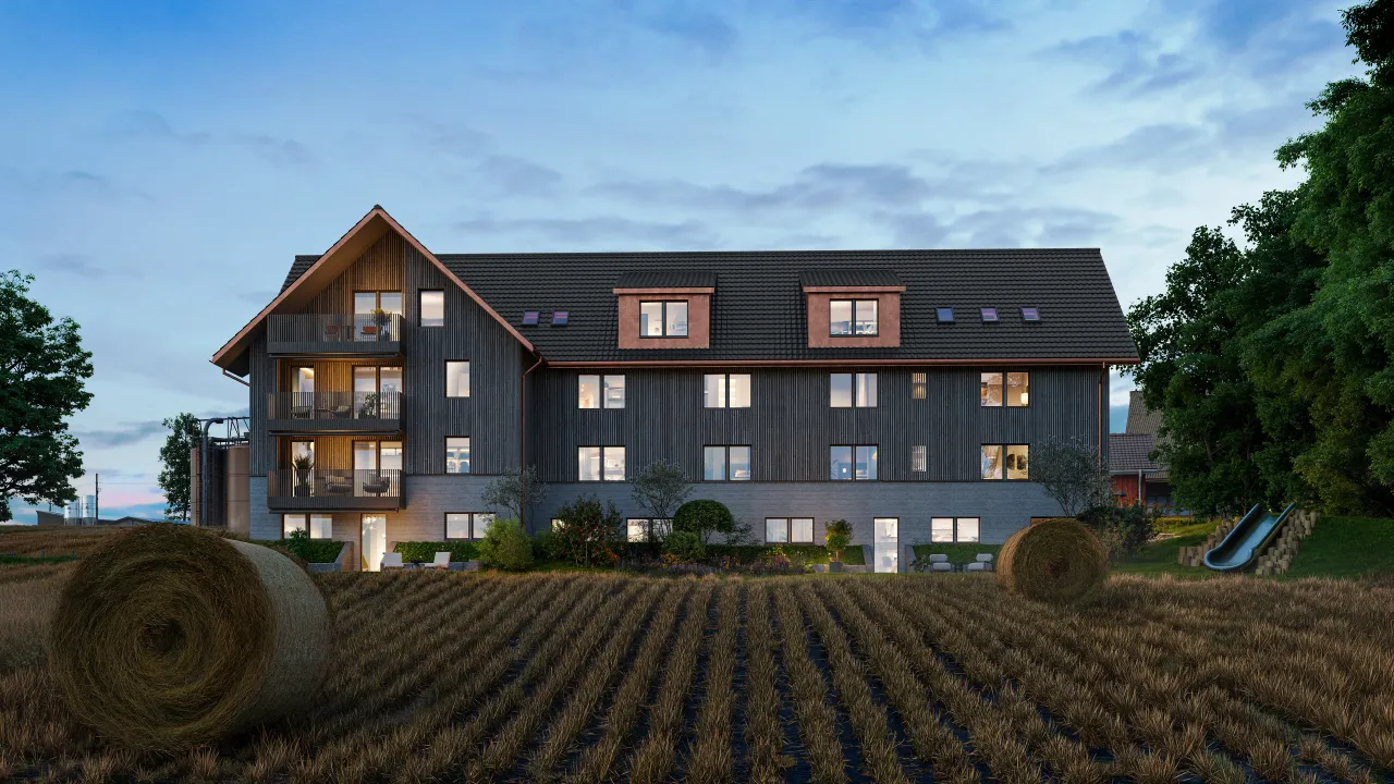Exterior rendering of a dark timber apartment house with dormers behind a ploughed field and straw bales under a blue sky